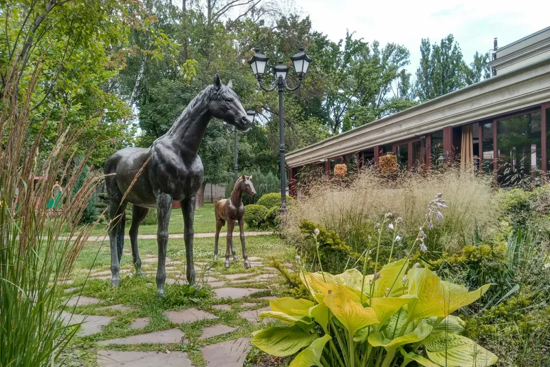 Esculturas de caballos en un parque de arte al aire libre rodeado de vegetación