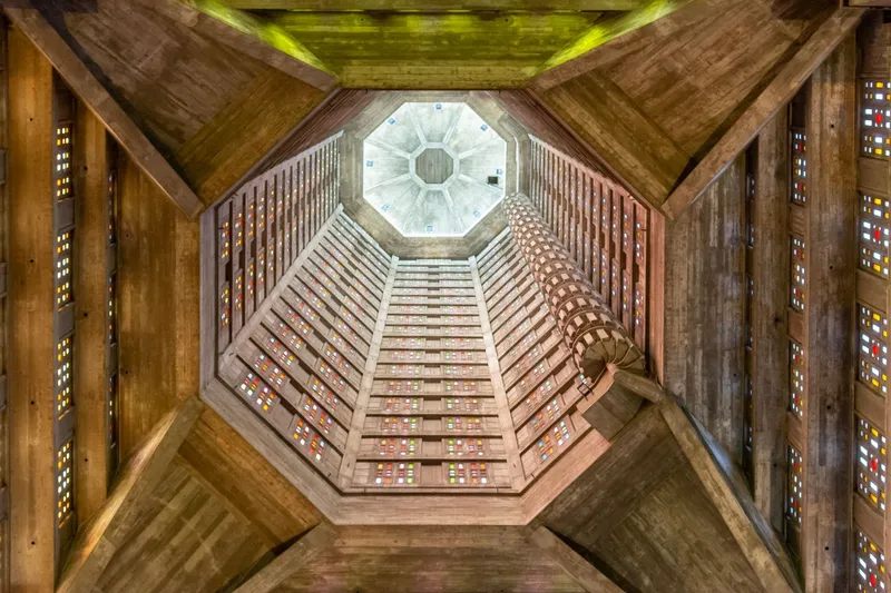 Escalera de caracol rodeada por muros de vidrieras de colores en el interior de la Torre Sinfónica.