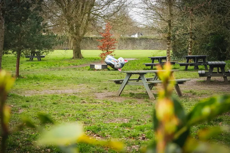 Mesas de pícnic al aire libre en un parque de esculturas contemporáneas