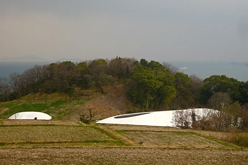 Pabellón blanco del Museo de Arte de Teshima entre bancales de arroz junto al mar