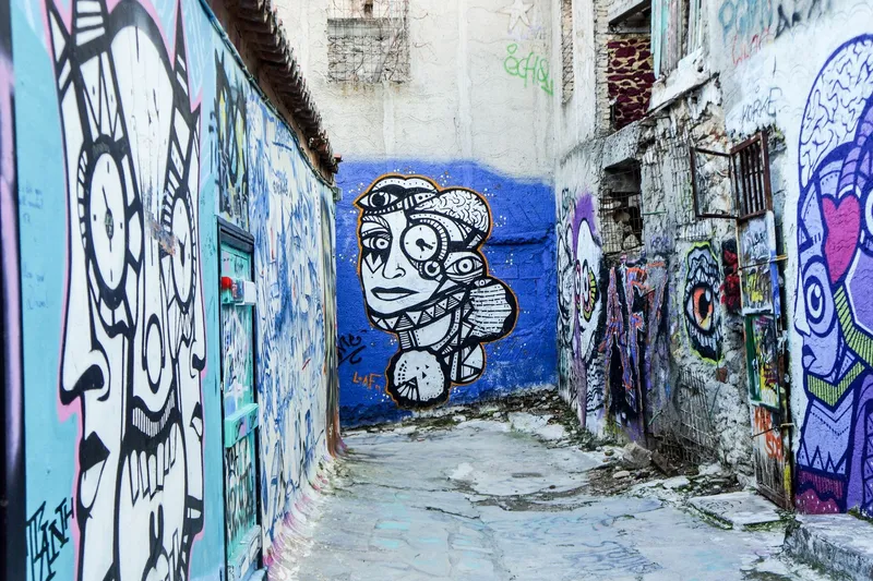 Calle urbana de un distrito artístico, rodeada de grandes murales de arte callejero