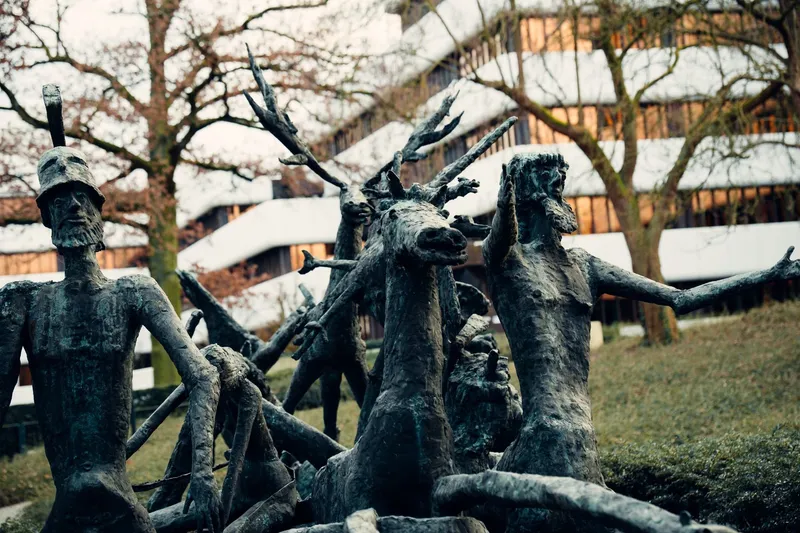 Esculturas monumentales en un parque al aire libre con nieve y árboles desnudos